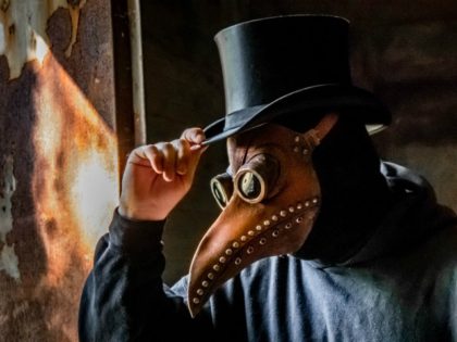 A cosplay of a black plague doctor in a top hat.
