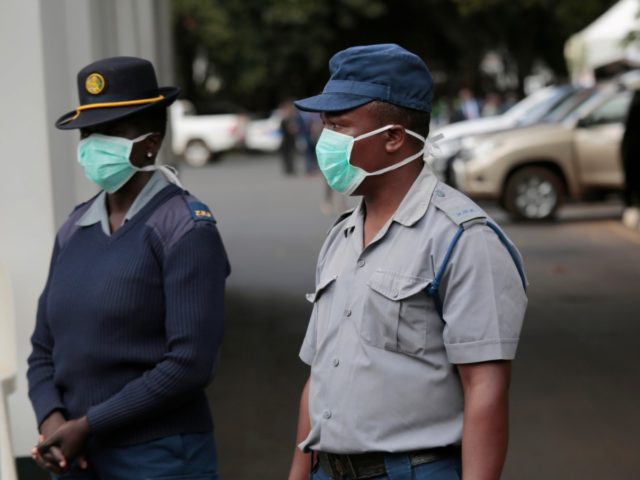 Zimbabwean police wear face masks during a coronavirus awareness campaign launch at State House in Harare, Thursday, March, 19, 2020. For most people, the new coronavirus causes only mild or moderate symptoms. For some it can cause more severe illness, especially in older adults and people with existing health problems. …