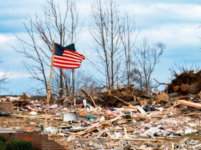 A flag flaps in the wind as US President Donald Trump tours tornado damage in Cookeville, Tennessee on March 6, 2020. - At least 24 are dead in the wake of March 3 2020 terrible Tennessee tornadoes. They carved a long scar across Middle Tennessee in the dead of night, …