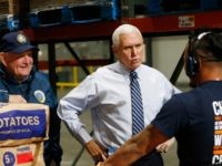 Vice President Mike Pence, center, talks with order picker Bin Sam, right, as Agriculture Secretary Sonny Perdue, left, listens during a tour of a Walmart Distribution Center Wednesday, April 1, 2020, in Gordonsville, Va. (AP Photo/Steve Helber)