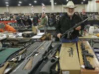 FILE - In this Jan. 6, 2013 file photo, Ken Haiterman, of Pioneer Market, holds a CMMG 5.56mm AR 15 during the 2013 Rocky Mountain Gun Show in Sandy, Utah. A bipartisan quartet of senators, including two National Rifle Association members and two with “F” ratings from the potent firearms …