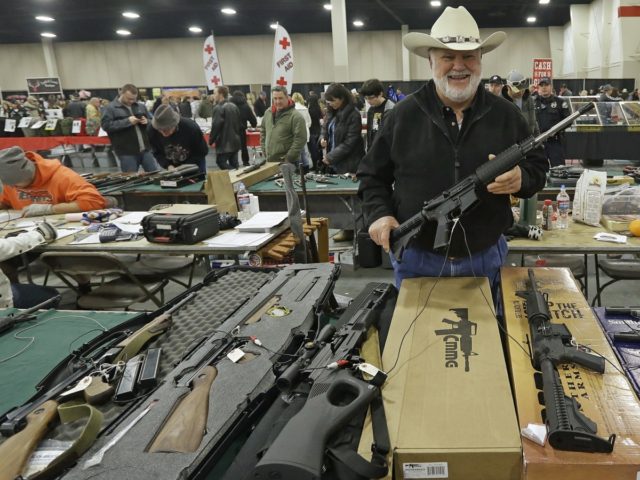 FILE - In this Jan. 6, 2013 file photo, Ken Haiterman, of Pioneer Market, holds a CMMG 5.56mm AR 15 during the 2013 Rocky Mountain Gun Show in Sandy, Utah. A bipartisan quartet of senators, including two National Rifle Association members and two with “F” ratings from the potent firearms …