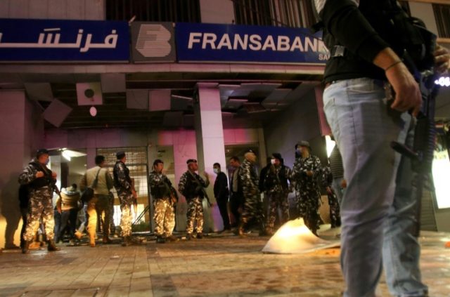 Lebanese security forces inspect the entrance to a Fransabank branch in the southern city of Sidon on April 25 after unknown assailants targeted it with an explosive device © AFP Mahmoud ZAYYAT