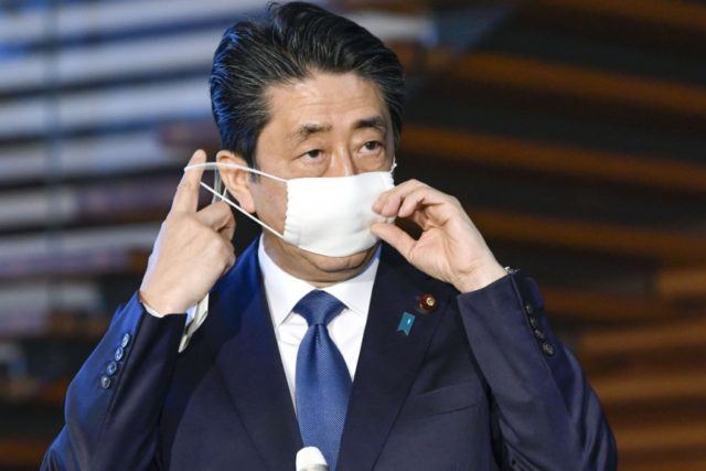 Japanese Prime Minister Shinzo Abe takes off mask as he speaks to reporters at the prime minister's official residence in Tokyo Monday, April 6, 2020. Abe said that he will declare a state of emergency for Tokyo and six other prefectures as early as Tuesday, April 7, to bolster measures …