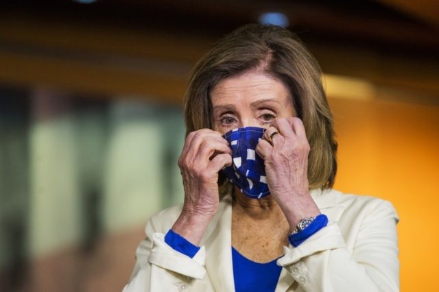 House Speaker Nancy Pelosi of Calif. adjusts her face mask during a news conference on Capitol Hill Thursday, April 30, 2020, in Washington. (AP Photo/Manuel Balce Ceneta)