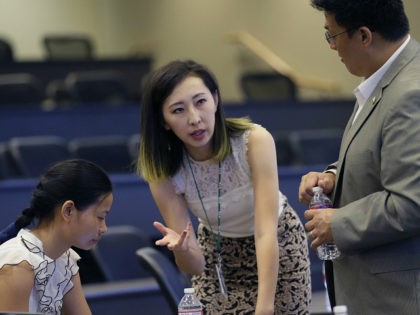 In this photo made Saturday, Aug. 22, 2015, Hua Bai, center, vice president of Friendship Association of Chinese Scholars and Students, prepares for an orientation for fellow Chinese students at the University of Texas at Dallas in Richardson, Texas. Bai from China last year to work on a master’s degree …