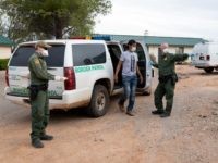 Border Patrol agents utilizing PPE and coronavirus protection protocols while processing an illegal alien. (CBP File Photo by Jerry Glaser)