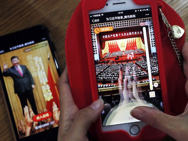 A woman poses as she playing a Tencent's smartphone game called "A Great Speech, clap for Xi Jinping" in Beijing, Friday, Oct. 20, 2017. Ordinary young Chinese may not have paid close attention to Xi Jinping's 3-and-a-half hour marathon speech this week, but they're happy to "applaud" the president in …