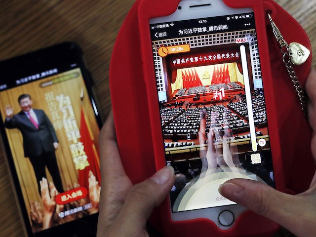 A woman poses as she playing a Tencent's smartphone game called "A Great Speech, clap for