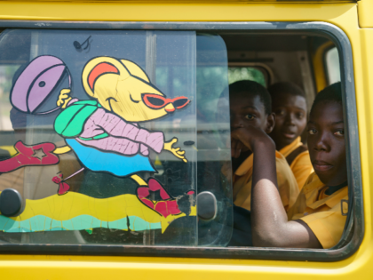 School boys ride in a bus on the N1 roadway seen from the moving media motorcade vehicle en route form Cape Coast, Ghana, to Accra Gonna, Wednesday, Oct. 3, 2018. A press pool is accompanying first lady Melania Trump on her first big solo international trip to Africa. (AP Photo/Carolyn …