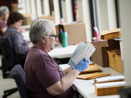 In this April 14, 2020 photo, Pam Fleming and fellow workers stuff ballots and instructions into mail-in envelopes at the Lancaster County Election Committee offices in Lincoln, Neb. Officials in Nebraska are forging ahead with plans for the state’s May 12 primary despite calls from Democrats to only offer voting …