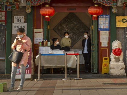 Clerks wear face masks to prevent the spread of the new coronavirus as they wait for custo