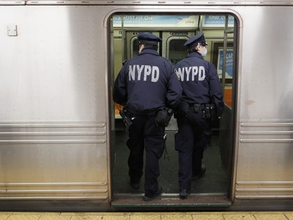 NYPD officers wake up sleeping passengers and direct them to the exits at the 207th Street A-train station, Thursday, April 30, 2020, during the coronavirus pandemic, in the Manhattan borough of New York. (AP Photo/John Minchillo)