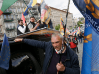 Workers of small business, some of them wearing face masks to protect from coronavirus, marsh demanding the government to stop the quarantine on a protest action in front of the Cabinet in Kyiv, Ukraine, Wednesday, May 6, 2020. About one hundred of businessmen gathered in front of the Cabinet claiming …