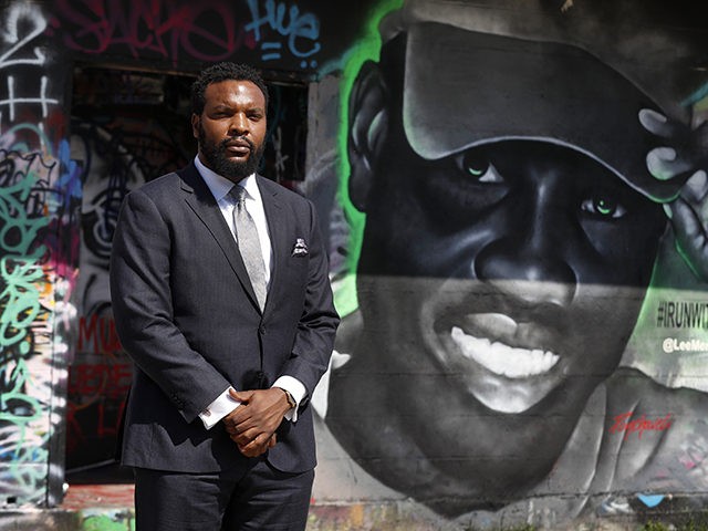 Lee Merritt, a lawyer representing the family of Ahmaud Arbery, poses for a photo by a mural in the likeness of Arbery painted by artist Theo Ponchaveli in Dallas, Saturday, May 9, 2020. Arbery’s mother, Wanda Cooper Jones, has said she thinks her son, a former high school football player, …