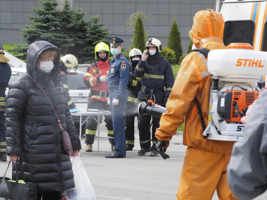 A Russian Emergency Situation worker disinfects a woman near the scene of a fire at St. George Hospital in St. Petersburg, Russia, Tuesday, May 12, 2020. A fire at St. George Hospital has killed five coronavirus patients. Russian emergency officials said all five had been put on ventilators. The emergency officials told the state Tass new agency the fire broke out in an intensive care unit and was put out within half an hour. (AP Photo/Dmitry Lovetsky)