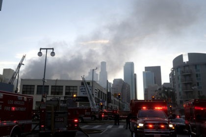 Smoke rises from the scene of a structure fire that injured multiple firefighters, accordi