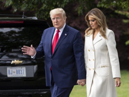 President Donald Trump, accompanied by first lady Melania Trump, waves as they walk to dep