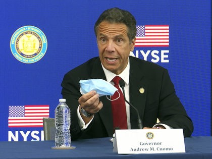 New York Gov, Andrew Cuomo holds his face mask while talking to the media at the New York Stock Exchange, Tuesday, March 26, 2020. Gov. Cuomo rang the opening bell as the trading floor partially reopened during the coronavirus pandemic. (AP Photo/Ted Shaffrey)