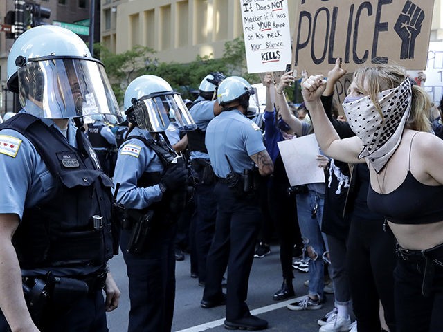 People confront police officers during a protest over the death of George Floyd in Chicago