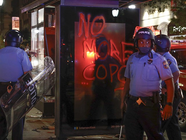Philadelphia police patrol the streets near a bus stop with graffitti after the Justice for George Floyd Philadelphia Protest on Saturday, May 30, 2020 in Philadelphia. Floyd died in Minneapolis police custody on Memorial Day, May 25, after an officer pressed his knee into his neck for several minutes even …