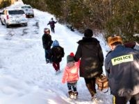 Family members from Somalia are escorted to waiting vehicles by Royal Canadian Mounted Police. (Paul Chiasson/The Canadian Press via AP)