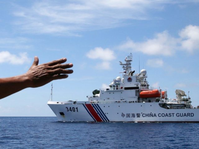 In this photo taken March 29, 2014, Philippines navy personnel motions towards a Chinese Coast Guard to make way as they block them from entering Second Thomas Shoal in the South China Sea. The Permanent Court of Arbitration (PCA) issued its ruling Tuesday, July 12, 2016, in The Hague in …