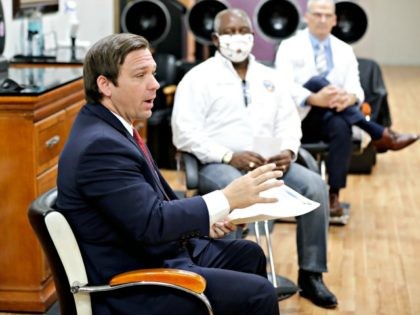 Florida Gov. Ron DeSantis, left, speaks during a discussion about opening businesses such