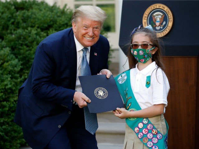 President Donald Trump poses for a photo with Girl Scout Troop 744 member Lauren Matney du