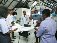n this April 2, 2020, file photo, a health inspection officer shows doctors how to use protective equipment before they head to a ward at Mbagathi hospital for patients under quarantine with confirmed cases of the coronavirus, at Kenyatta National Hospital in Nairobi, Kenya. A global “brain drain” of medical …