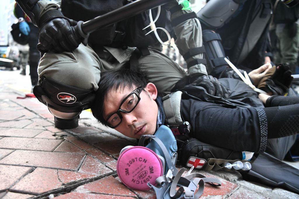 TOPSHOT - A protester is detained by police as violent demonstrations take place in the streets of Hong Kong on October 1, 2019, as the city observes the National Day holiday to mark the 70th anniversary of communist China's founding. - Police fanned out across Hong Kong on October 1 in a bid to deter pro-democracy protests as the city marked communist China's 70th birthday, with local officials attending a closed door flag-raising ceremony behind closed doors. (Photo by Anthony WALLACE / AFP) (Photo by ANTHONY WALLACE/AFP via Getty Images)