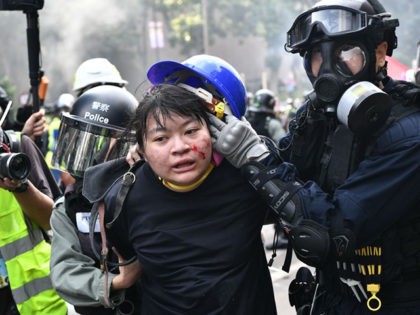 TOPSHOT - Protesters are detained by police near the Hong Kong Polytechnic University in Hung Hom district of Hong Kong on November 18, 2019. - Pro-democracy demonstrators holed up in a Hong Kong university campus set the main entrance ablaze on November 18 to prevent surrounding police moving in, after …