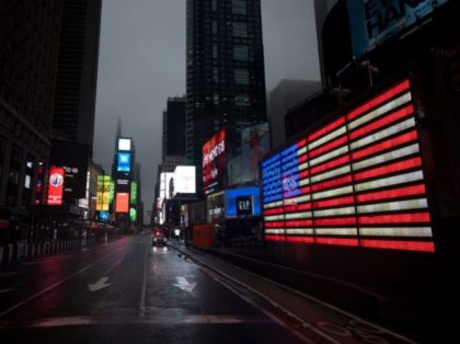 TOPSHOT - The US Flag illuminates a street in Times Square amid the Covid-19 pandemic on A