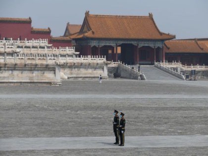 Paramilitary police officers wear face masks as a preventive measure against the COVID-19 coronavirus as they stand guard in the Forbidden City, the former palace of China's emperors, in Beijing on May 1, 2020. - With optimism and a heavy dose of caution, millions of Chinese hit the road or …