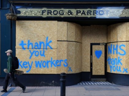 People walk past graffiti street art, praising the workers of Britain's NHS (National