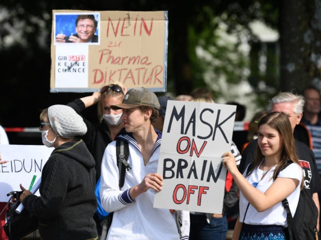 MUNICH, GERMANY - MAY 16: Protesters hold signs reading Mask on, brain off and I am not a conspirator, I am just a mother and Give Gates no chance during a protest of about 1000 people against lockdown measures and other government policies relating to the novel coronavirus crisis on …