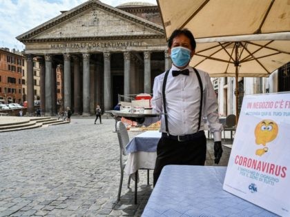 A waiter is pictured at a cafe terrace by the Pantheon monument in central Rome on May 18, 2020 during the country's lockdown aimed at curbing the spread of the COVID-19 infection, caused by the novel coronavirus. - Restaurants and churches reopen in Italy on May 18, 2020 as part …