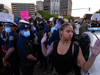 Protesters hold their hands up and chant hands up dont shoot. while Detroit Police officers look on, during a protest in the city of Detroit, Michigan, on May 29, 2020, over the death of George Floyd, a black man who died after a white policeman knelt on his neck for …