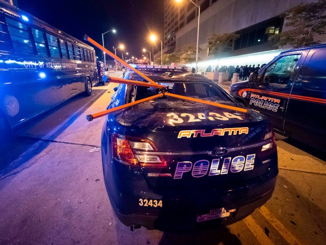 A police car is vandalized during rioting and protests in Atlanta on May 29, 2020. - The d