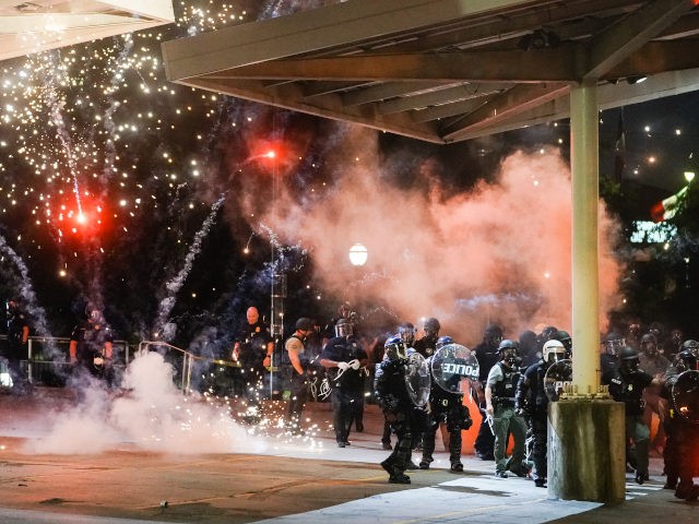 ATLANTA, GA - MAY 30: A firework explodes near a police line during a protest in response to the police killing of George Floyd on May 30, 2020 in Atlanta, Georgia. Across the country, protests have erupted following the recent death of George Floyd while in police custody in Minneapolis, …