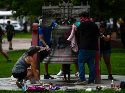 DENVER, CO - MAY 31: People work to clean off graffiti from a replica of the Liberty Bell during the fourth consecutive day of protests in the aftermath of the death of George Floyd on May 31, 2020 in Denver, Colorado. The city of Denver enacted a curfew for Saturday …