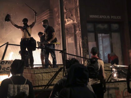 MINNEAPOLIS, MINNESOTA - MAY 28: Protesters gather in front of the 3rd precinct police building while it burns on May 28, 2020 in Minneapolis, Minnesota. Today marks the third day of ongoing protests after the police killing of George Floyd. Four Minneapolis police officers have been fired after a video …