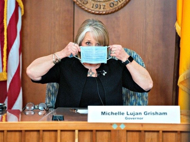 Gov. Michelle Lujan Grisham holding a face mask in between speaking at a coronavirus press conference in Santa Fe, N.M.Credit...Eddie Moore/The Albuquerque Journal, via Associated Press