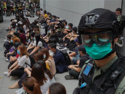 Hong Kong riot police guard detained anti-government protesters in the Causeway Bay district of Hong Kong, Wednesday, May 27, 2020. Hong Kong police massed outside the legislature complex Wednesday, ahead of debate on a bill that would criminalize abuse of the Chinese national anthem in the semi-autonomous city. (AP Photo/Vincent …