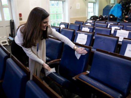 CNN's Kaitlan Collins cleans a seat in the James Brady Briefing Room before President Dona