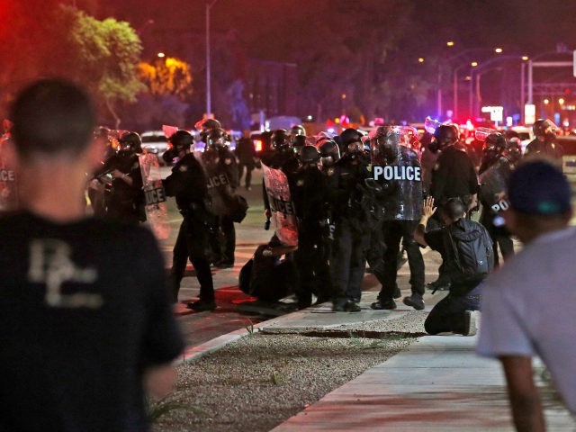 Police in riot gear move in to break up a group of marchers as hundreds take to the streets to protest against the recent fatal shootings of black men by police Friday, July 8, 2016, in Phoenix. Freeway ramps were closed and pepper spray and tear gas were used Friday …