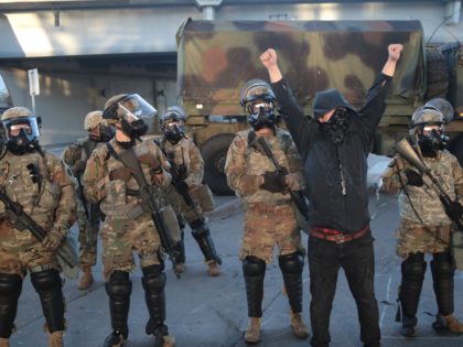 MINNEAPOLIS, MINNESOTA - MAY 29: A protester stands in front of a line of National Guardsm