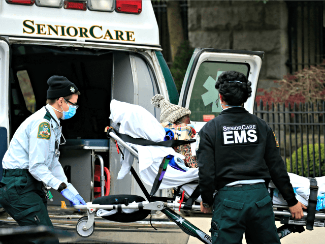 NEW YORK, NEW YORK - APRIL 18: Emergency Medical Service workers unload a patient out of their ambulance at the Cobble Hill Health Center on April 18, 2020 in the Cobble Hill neighborhood of the Brooklyn borough of New York City. The nursing home has had at least 55 COVID-19 …
