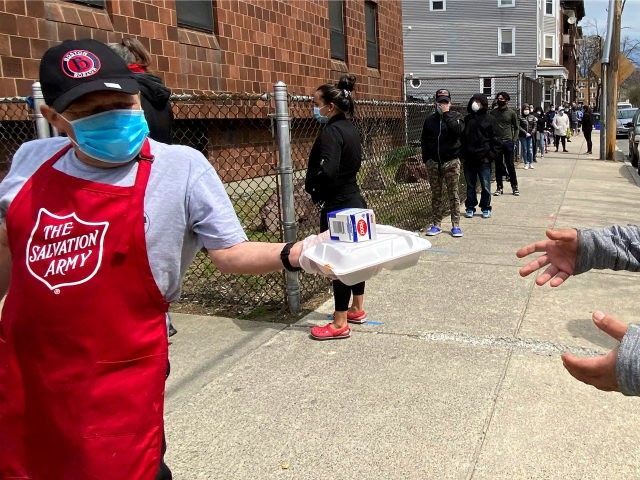 A Salvation Army worker, left, wears a mask out of concern about the coronavirus while han