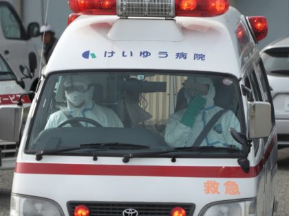 Officials in protective suits drive an ambulance near the cruise ship Diamond Princess anchored at the Yokohama Port in Yokohama, near Tokyo Friday, Feb. 7, 2020. Japan on Friday reported 41 new cases of a virus on a cruise ship that's been quarantined in Yokohama harbor while the death toll …
